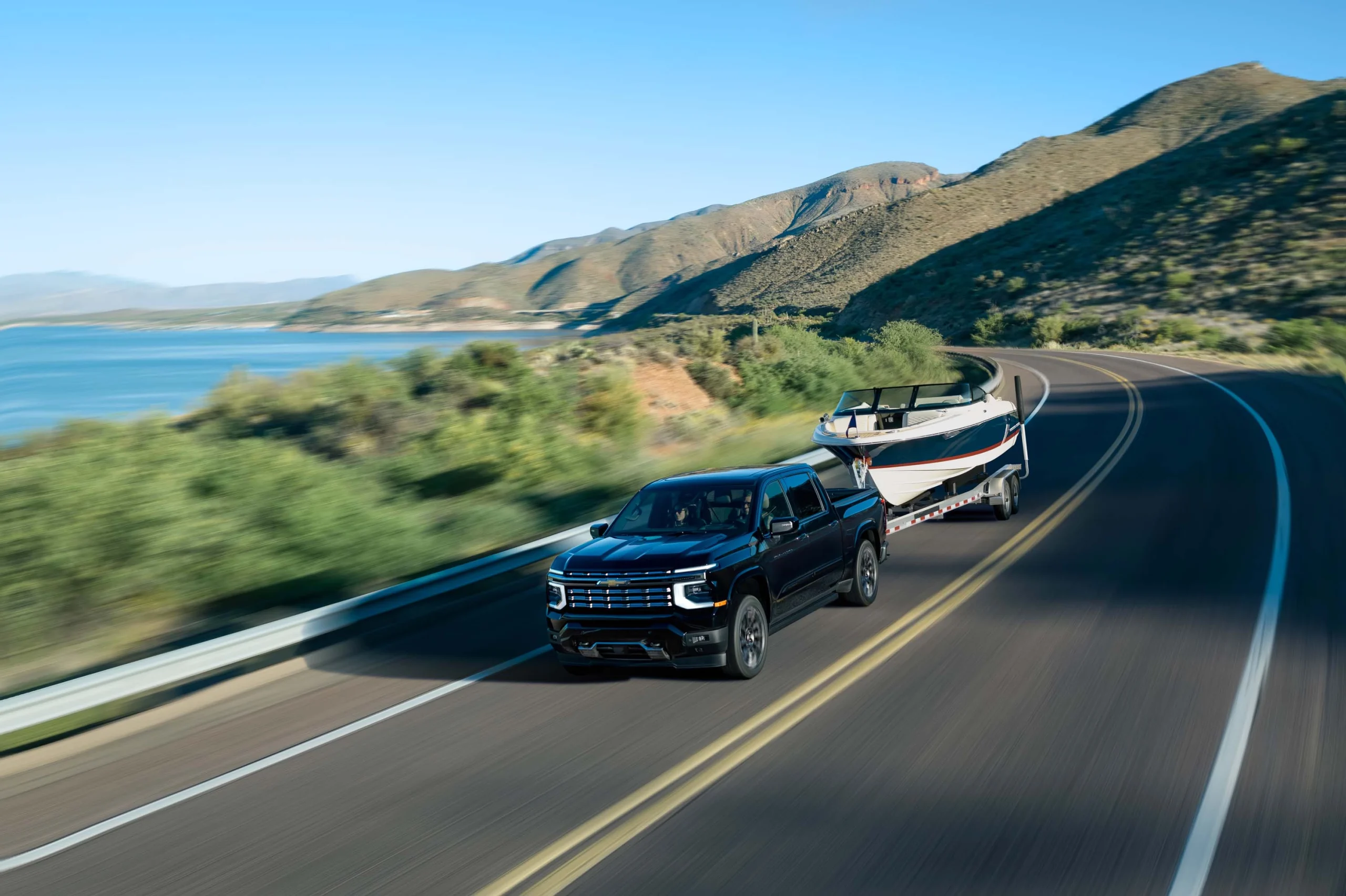 2027 Chevrolet Silverado 1500 towing a boat (preproduction model shown)
