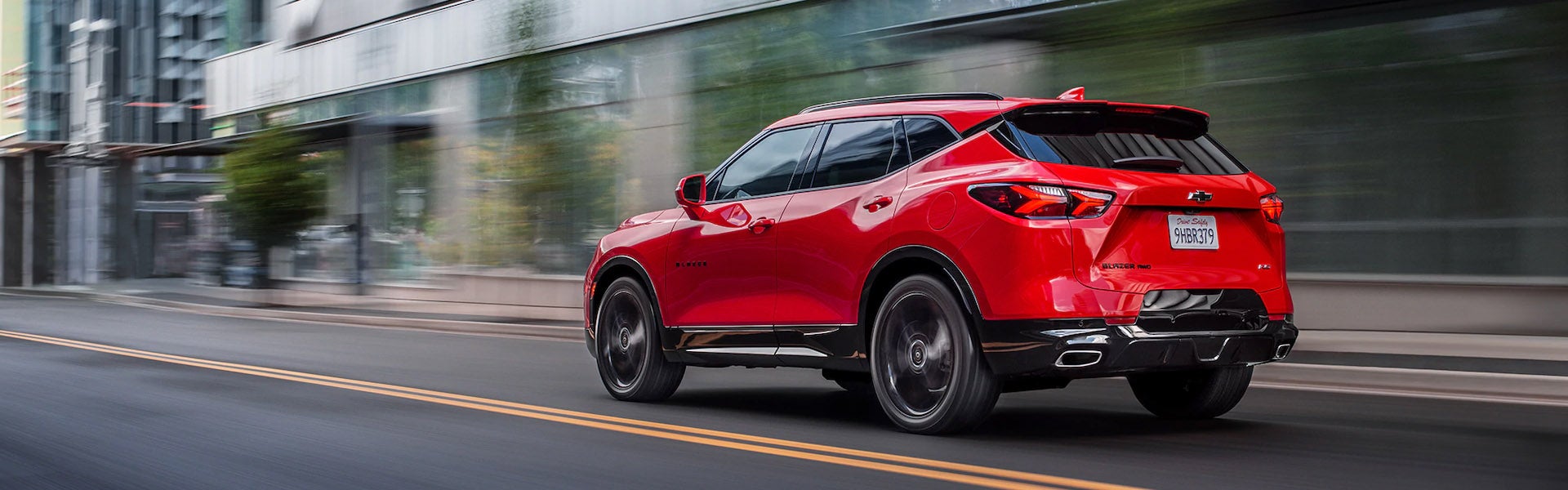 Red 2019 Chevy Blazer driving down city road