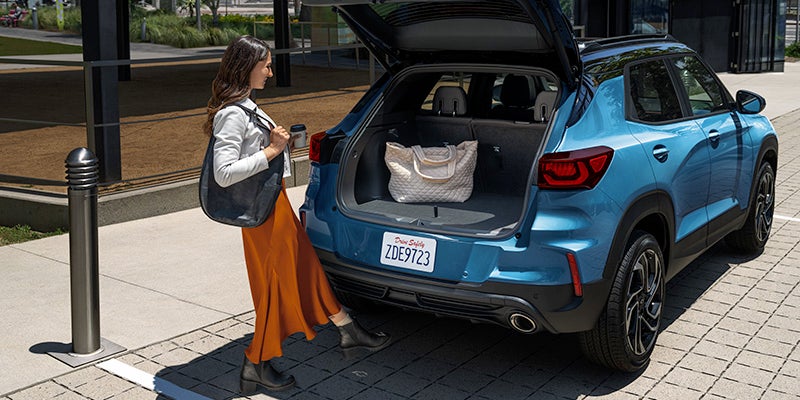 Woman opening trunk of blue 2025 Chevrolet Trailblazer