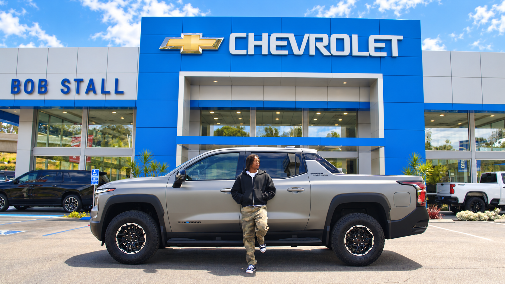  NFL wide receiver and San Diego native Rashid Shaheed leans back on a Chevy truck outside the Bob Stall Chevrolet dealership in La Mesa, CA, on the set of the dealership's 2026 football-season commercial.