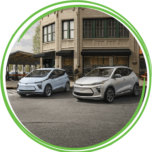 Electric Chevy Bolt driving on a bridge with a scenic cloudy sky in the background.
